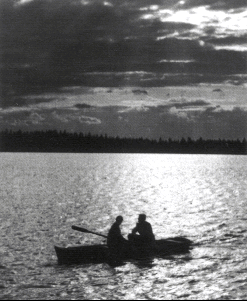 Two people on the boat in the middle of lake