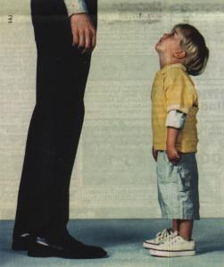 High man standing and small small boy looking at him
