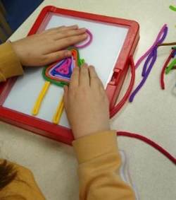 Afbeelding met Kinderkunst, persoon, verbruiksartikelen voor kantoor, overdekt