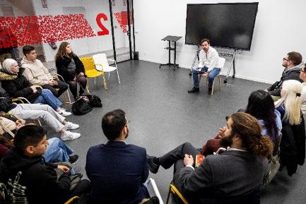 A room where the workshop took place with ten students in circle and the expert in front of them explaining something