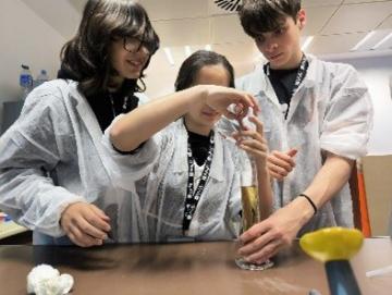 Three student using a test tube during the cience workshop