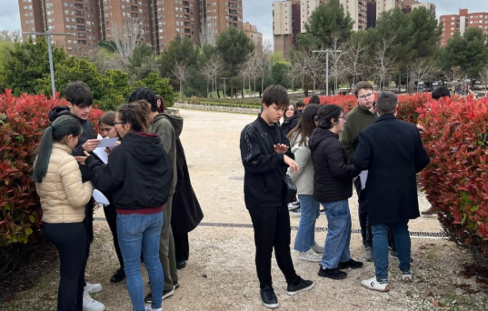 A gruop pf students and teachers in a park testing trees and flowers